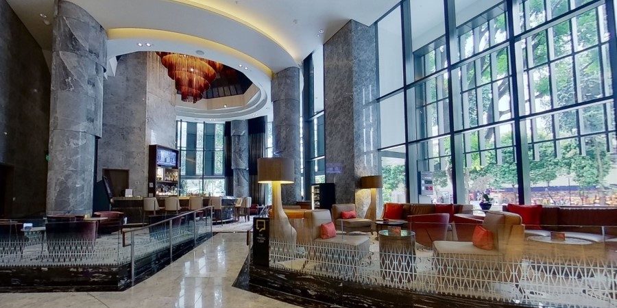 Spacious hotel lobby with expansive windows and a large artwork, enhancing the elegant ambiance of the space.